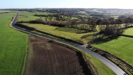 Toma-Aérea-De-Una-Carretera-A-Través-De-La-Campiña-Del-Este-De-Devon-En-Un-Hermoso-Día-Claro-Y-Soleado