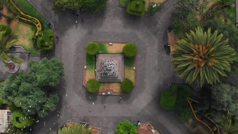 Toma-Aérea-Con-Drones-Sobre-La-Estatua-De-Juan-Montalvo-Con-Una-Bandada-De-Pájaros-Volando-Debajo