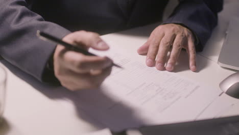 unrecognizable man in suit filling in application form