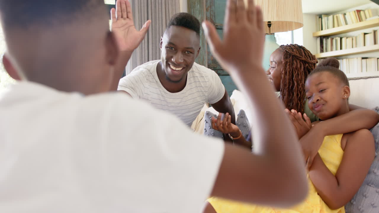 Smiling family sitting on couch, enjoying time together at home