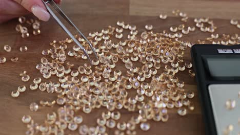 Close-up of a jeweler sorting and weighing loose gemstones