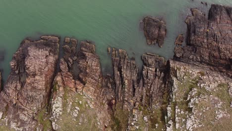 toma aérea de arriba hacia abajo de la costa rocosa y los acantilados frente al océano atlántico en uruguay