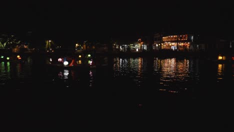 peaceful night scene of thu bon river in hoi an, vietnam, with beautifully decorated boats floating on the water, adorned with colorful lanterns