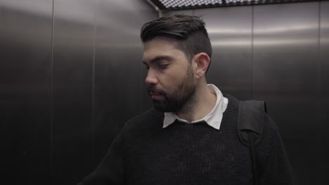 An-office-man-walks-into-an-office-building-elevator-lift-with-he-camera-moving-forward-to-a-close-up-of-his-face