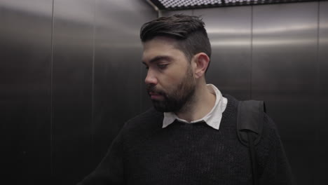 un oficinista entra en el ascensor de un edificio de oficinas con la cámara avanzando hacia un primer plano de su cara