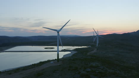 wind farm at sunset over a reservoir