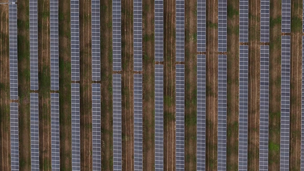 Vista aerea dall'alto di un grande parco fotovoltaico in Ungheria, che mostra file geometriche di pannelli fotovoltaici.