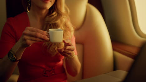 closeup stylish businesswoman working remotely on airplane. focused blonde enjoy