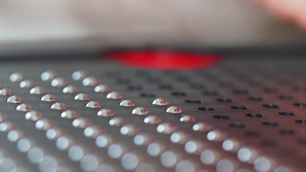 Person using a yellow pen on a black metal grid puzzle