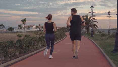 couple running on a coastal path at sunset