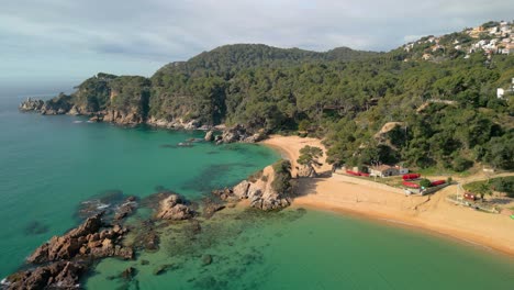 Contempla-Las-Impresionantes-Imágenes-Aéreas-De-La-Costa-Mediterránea-De-Lloret-De-Mar,-Destacando-Sus-Aguas-Turquesas-Y-Destinos-Turísticos-De-Lujo-Como-Santa-Cristina-Y-Cala-Treumal