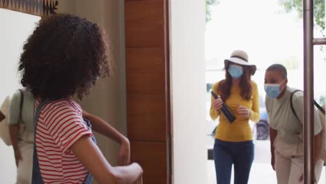 diverse group of happy female friends wearing mask greeting with elbow bump