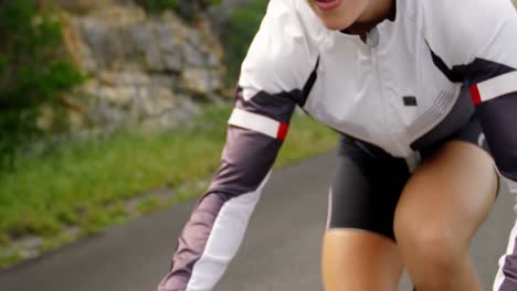 female cyclist cycling on a countryside road 4k