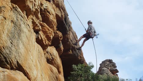 Mountaineer-rappelling-down-the-cliff-with-the-help-of-rope--4k-