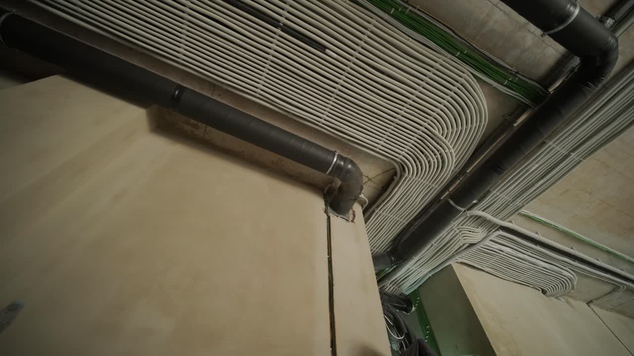 Electrical conduit and ventilation pipe on concrete ceiling