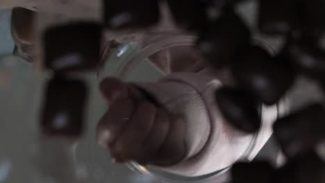 a girl takes a chocolate from a jar inside view