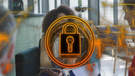 animation of security padlock icon over african american woman discussing with colleagues at office