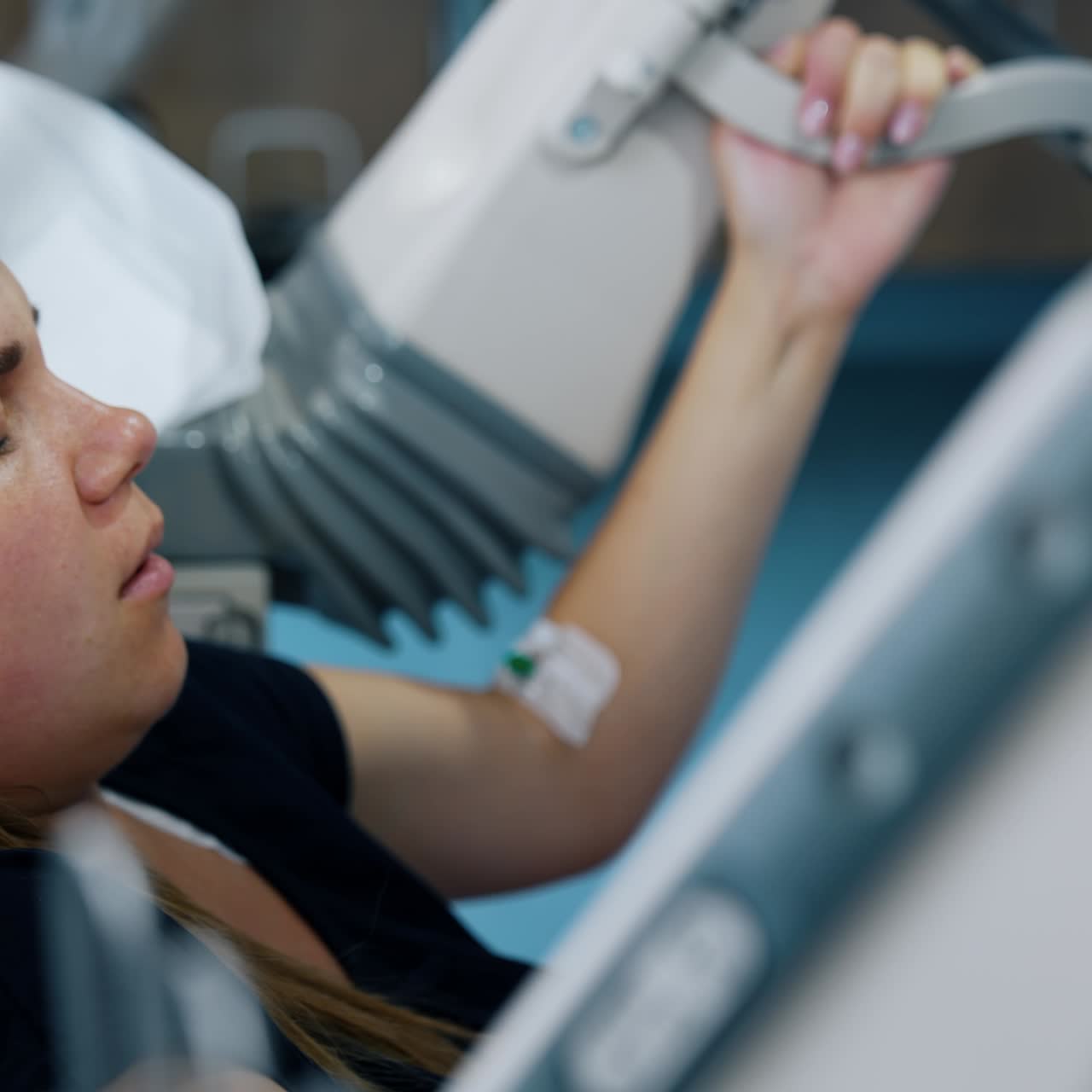 Painful process of childbirth. Caucasian woman becomes red as she pushes a baby. Side view portrait