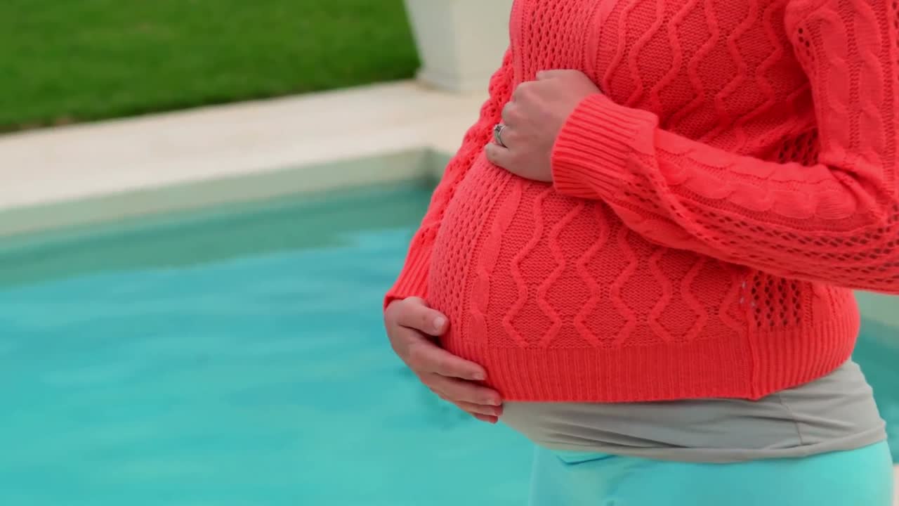 임신 한 여자는 그녀의 아랫 배를 만지고