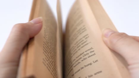 Un-Viejo-Libro-De-Cuentos-Volteando-Por-Manos-Femeninas,-Fondo-Blanco