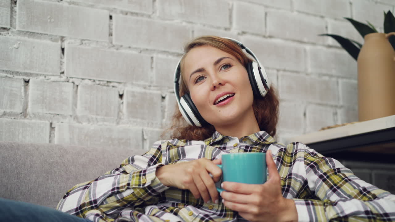 헤드폰과 커피를 들고 휴식을 취하는 여자