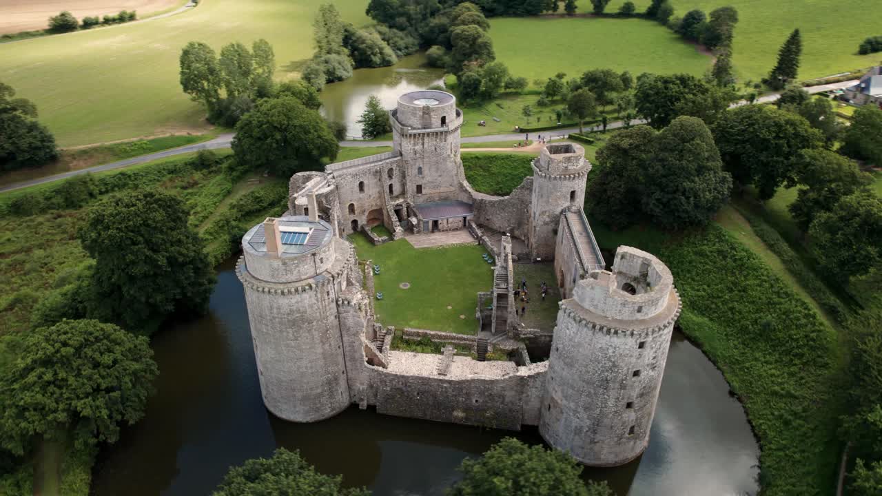 Ripresa ravvicinata con drone intorno al Castello di Hunaudaye, che mostra le diverse torri e il suo restauro, in una giornata nuvolosa d'estate, Bretagna, Francia.