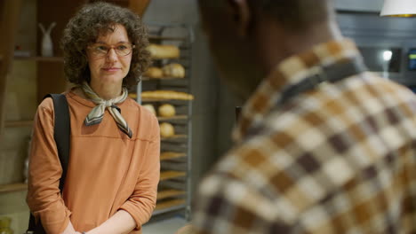 woman buying baguette at a bakery