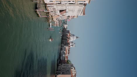 Vertikale-Aufnahme-Der-Berühmten-Grußkuppel,-Die-An-Einem-Sonnigen-Tag-Vom-Canal-Grande-In-Venedig,-Italien,-Aus-Gesehen-Wird