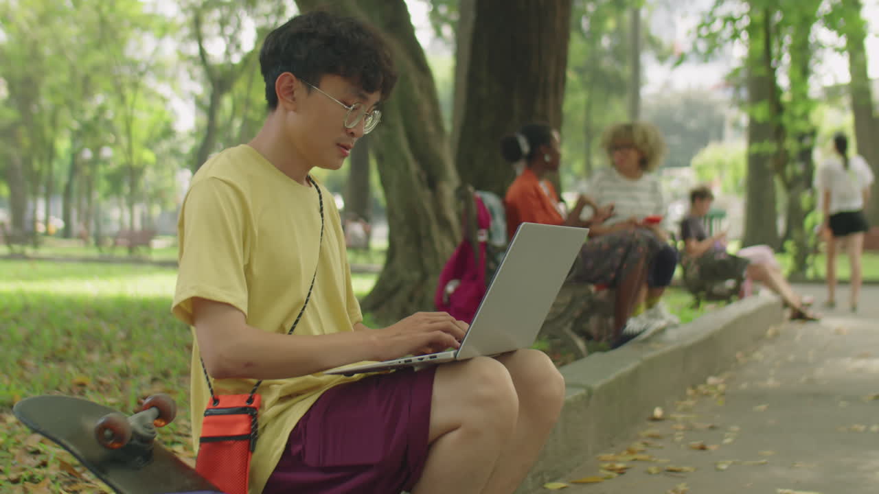 Asian Student Using Laptop in Park