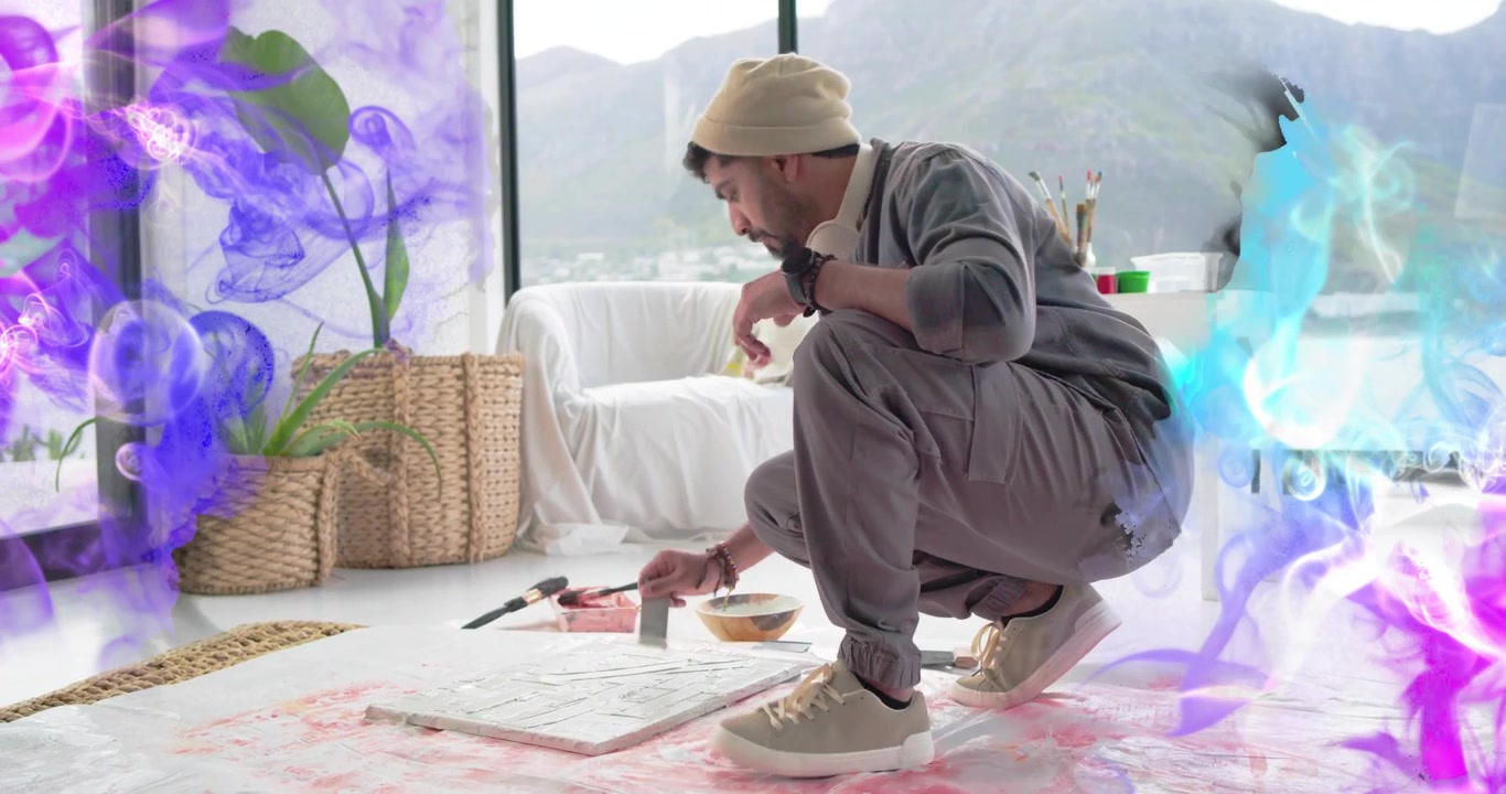 Artist choosing knife, applying paint on floor canvas refining work, purple blue smoke overlaying