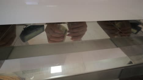 entrega de billetes a la caja registradora para su cambio