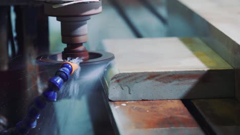 rounding the corner of a stone slab on a polisher using water. sandstone processing at the factory