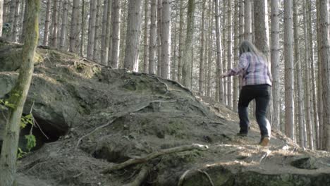 woman exploring pine forest wide shot