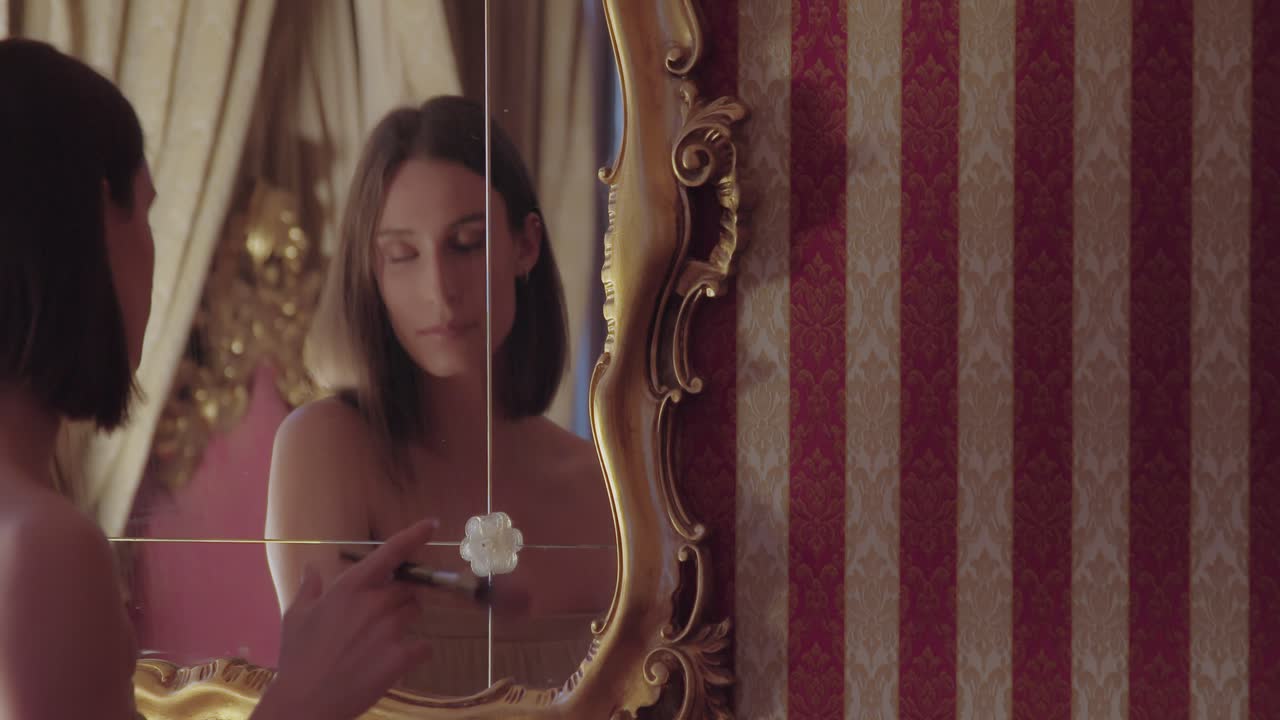 молодая женщина наносит макияж вечером