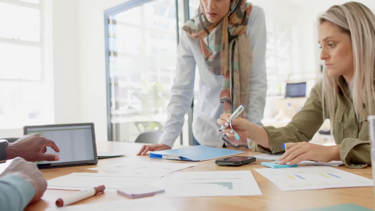 diversas personas de negocios ocupadas discutiendo el trabajo en la mesa con la tableta en cámara lenta