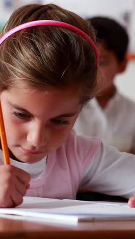 niña pequeña coloreando en el aula