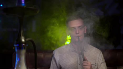 man smoking hookah in a lounge