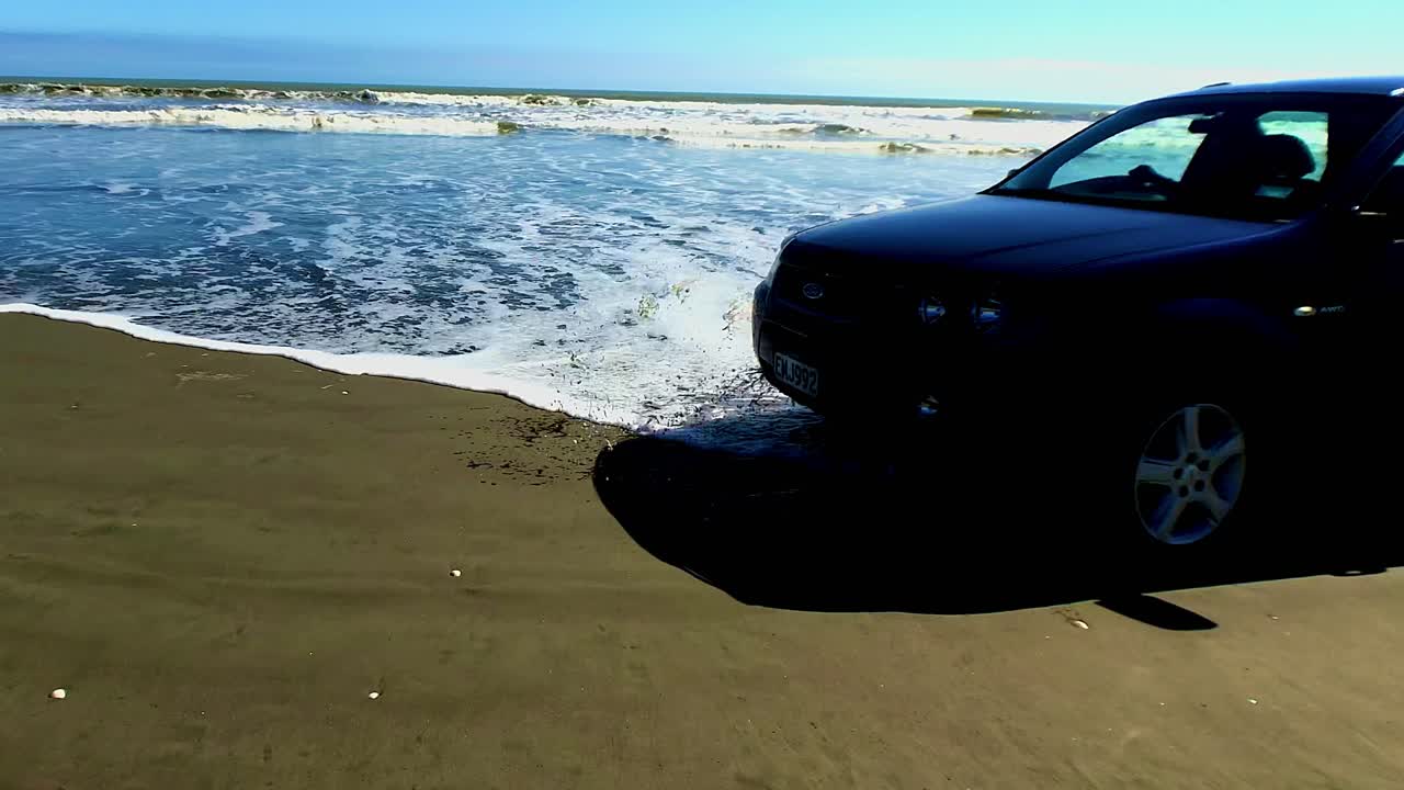 검은 모래 뉴질랜드 해변에 들어오는 조수