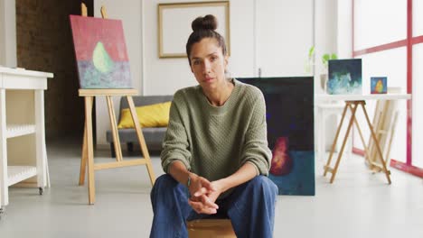 de un video de una artista biracial pintando en un estudio