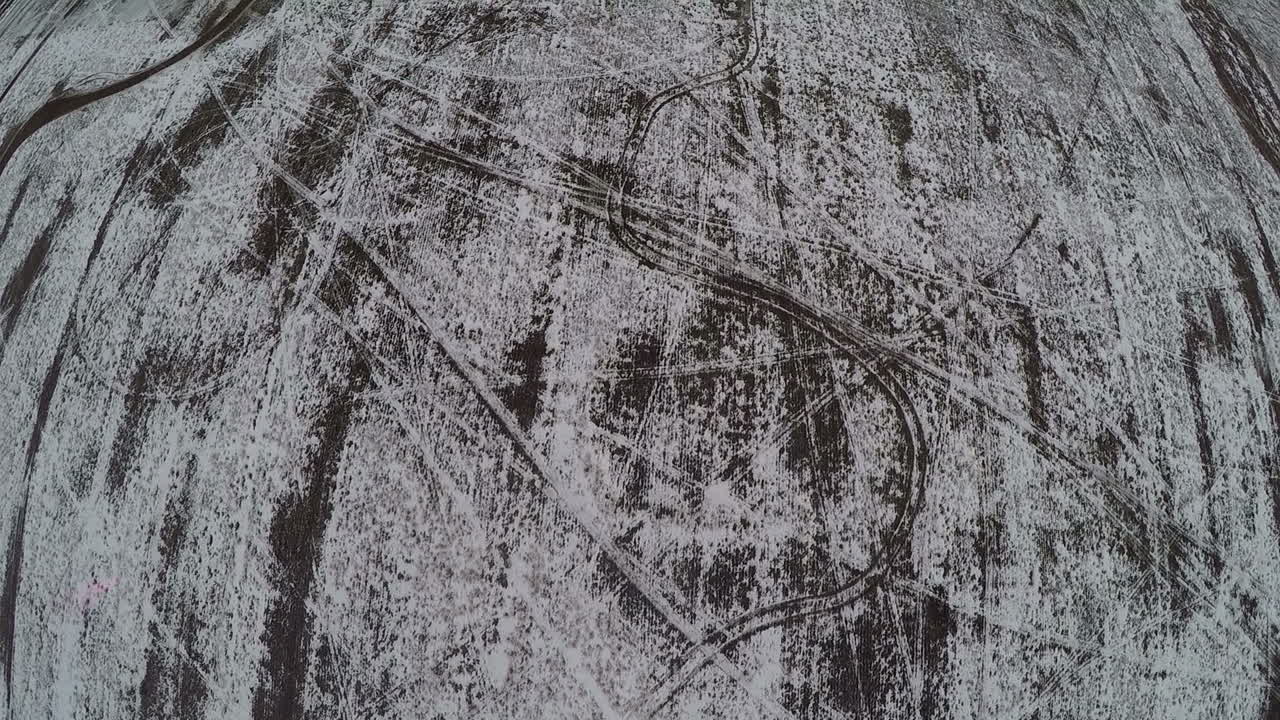 terreno plano nevado con huellas de automóviles tiro aéreo