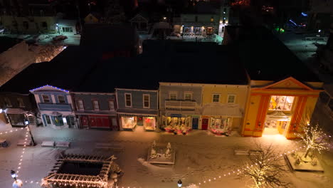 victorian storefronts, homes with christmas light decorations at night