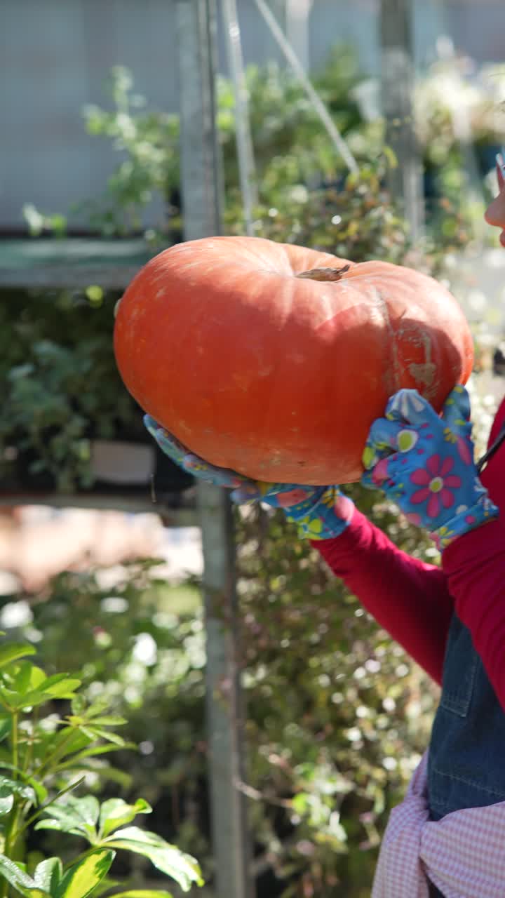 정원 센터 나 시장 에서 큰 오렌지색 호박 을 들고 있는 여자