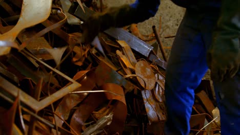 worker putting metal in wheelbarrow in foundry workshop 4k