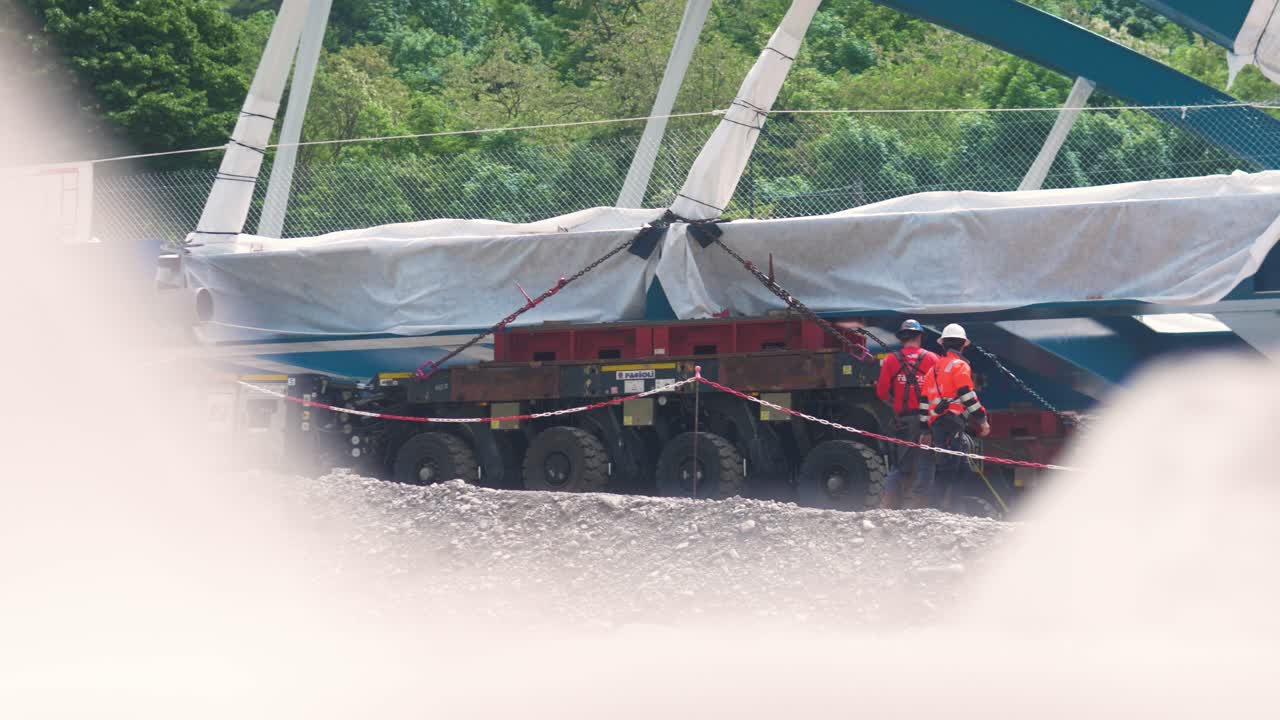 Workers operate heavy rigging equipment on a bridge construction site in Tende, South of France