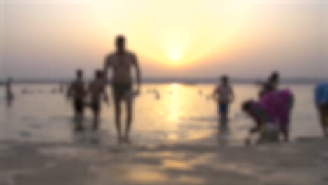 out of focus people bathing in ganges river