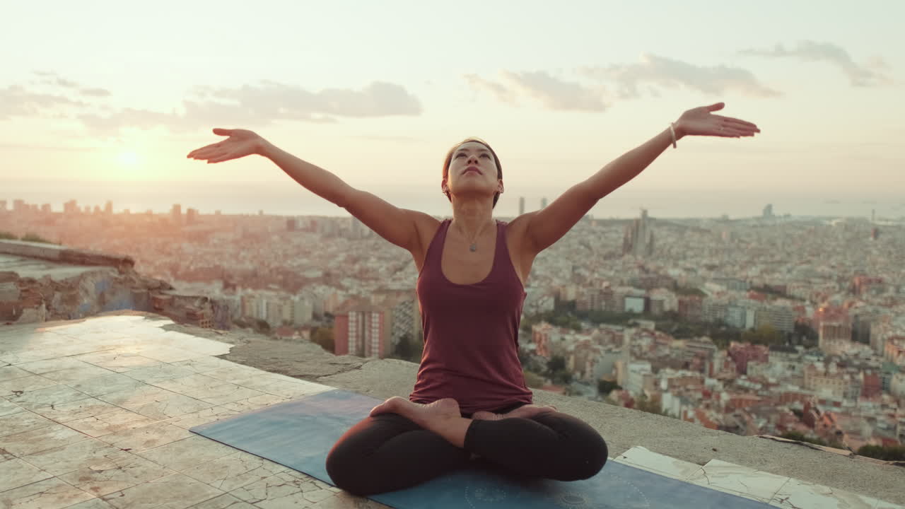 Woman Practicing Yoga at Sunrise Overlooking City