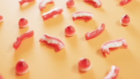 close up of multiple halloween candies fallen against orange background