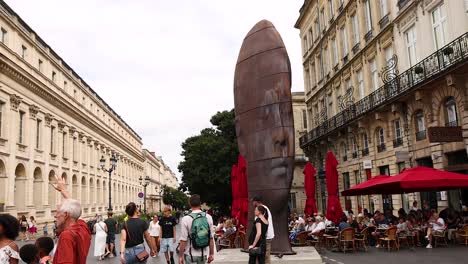 people walk past large sculpture in bordeaux