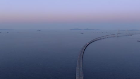 a long bridge over the sea at dawn