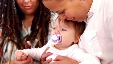 Happy-lesbian-couple-playing-with-daughter